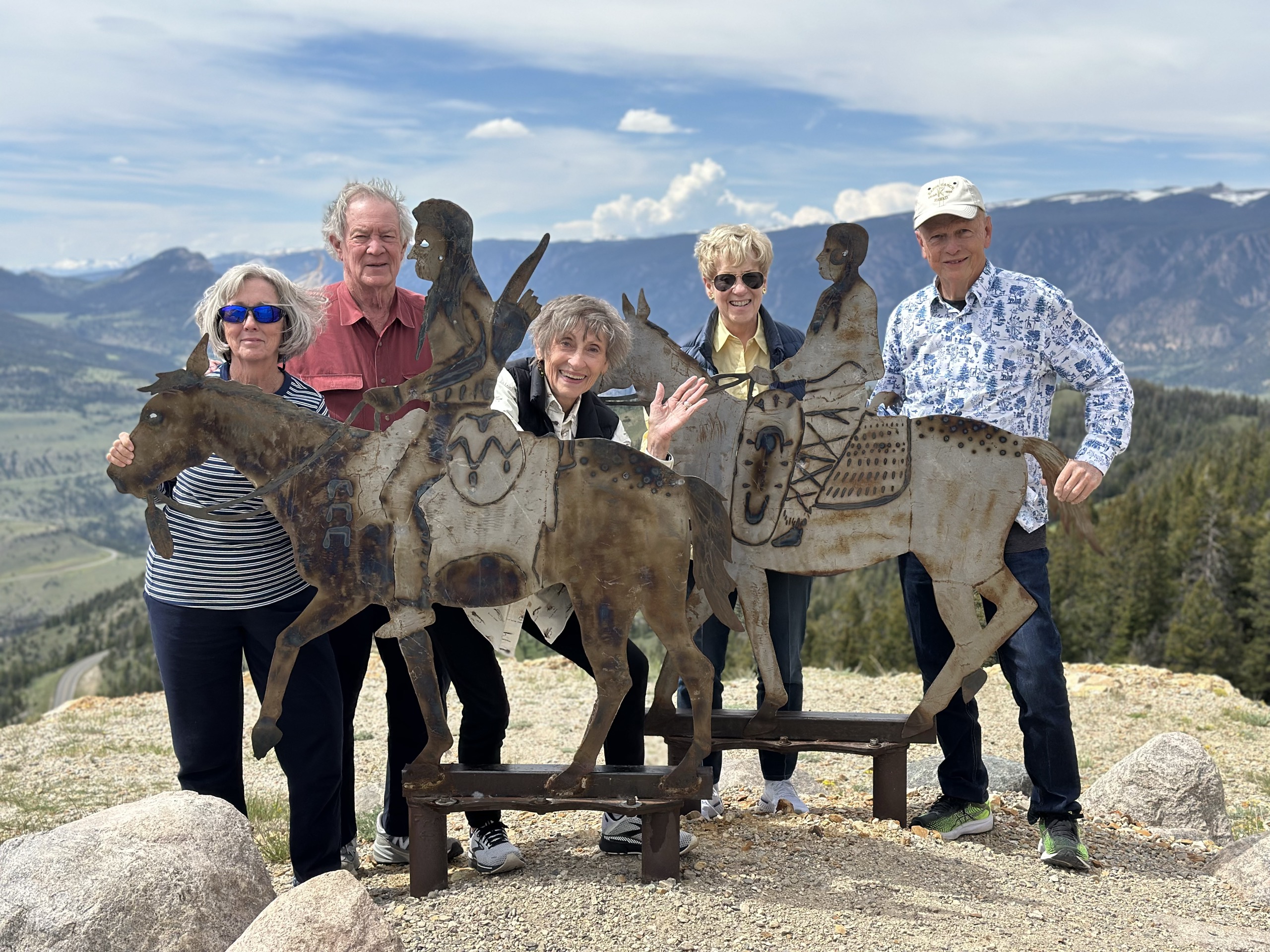 Guests at a mountaintop sculpture overlooking the valley