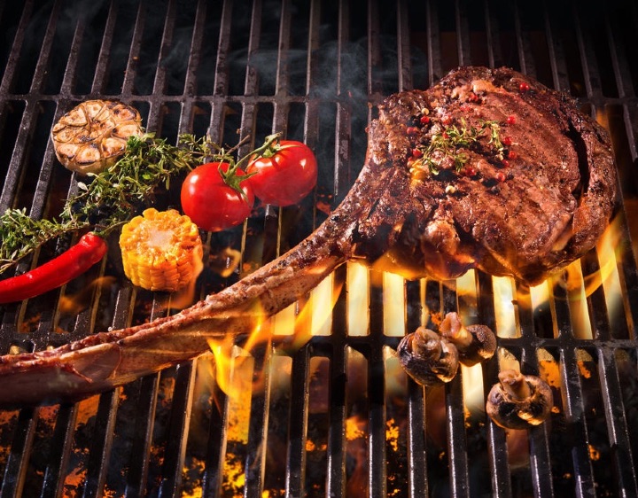 Tomahawk steak finishing on open flames at Montana Fly Fishing Lodge