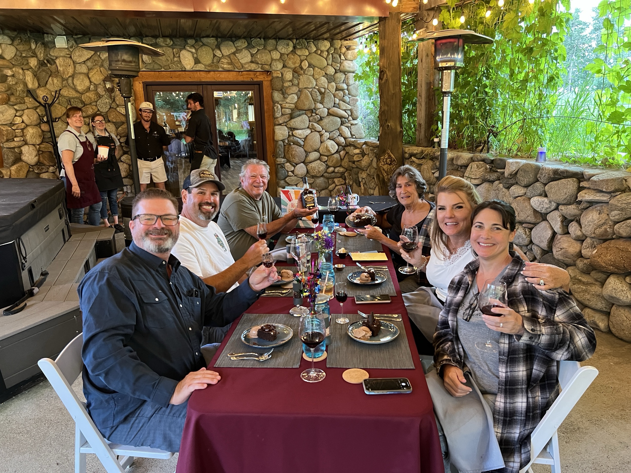 Guests raising wine glasses on the stone patio