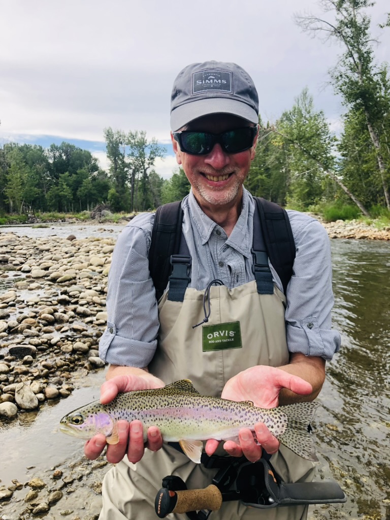 Rainbow trout held over clear spring creek water