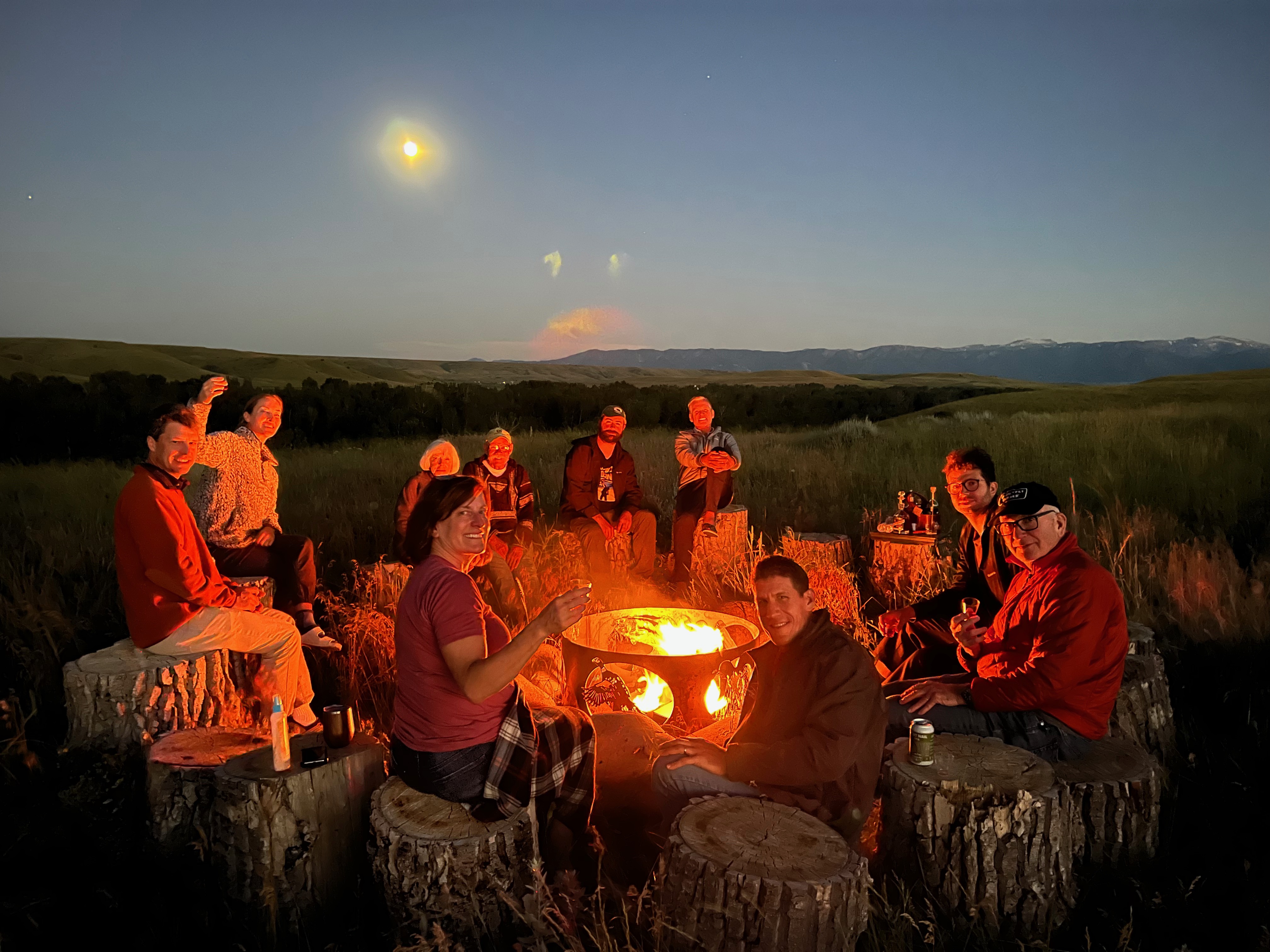 Guests gathered around the campfire under a Montana moon