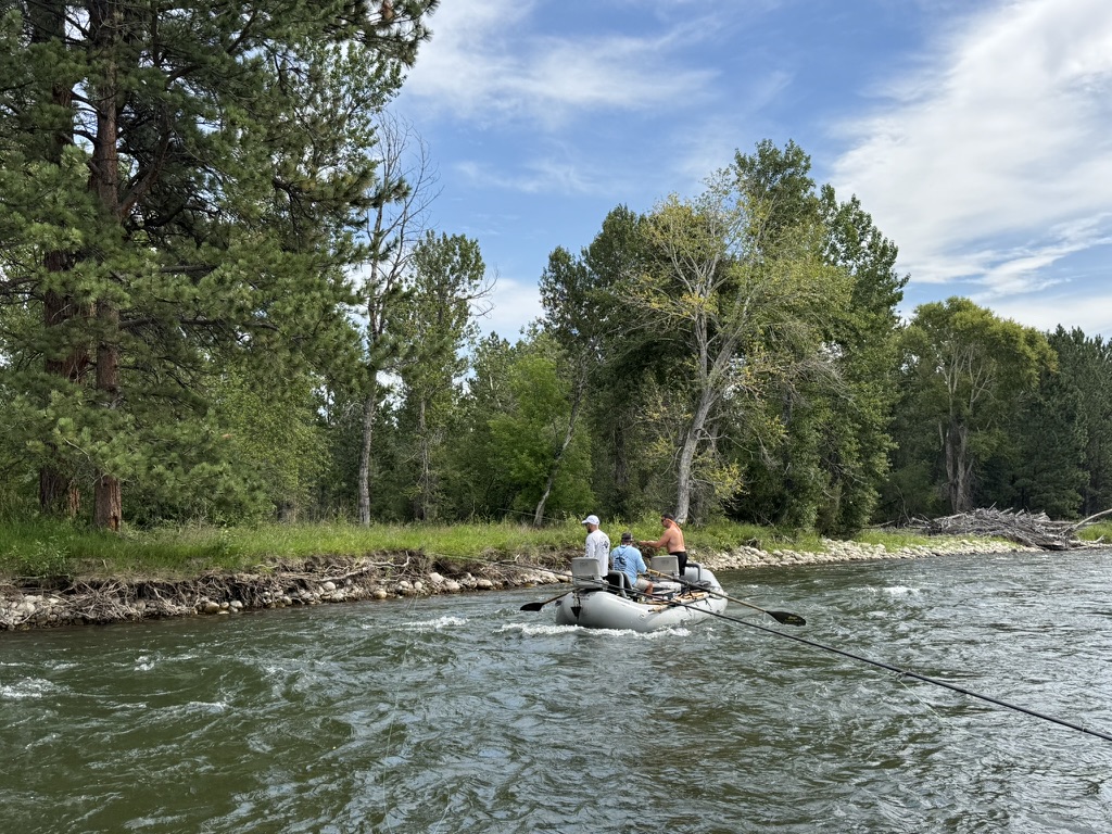 Guide, angler, and lodge dog on a Montana river trip